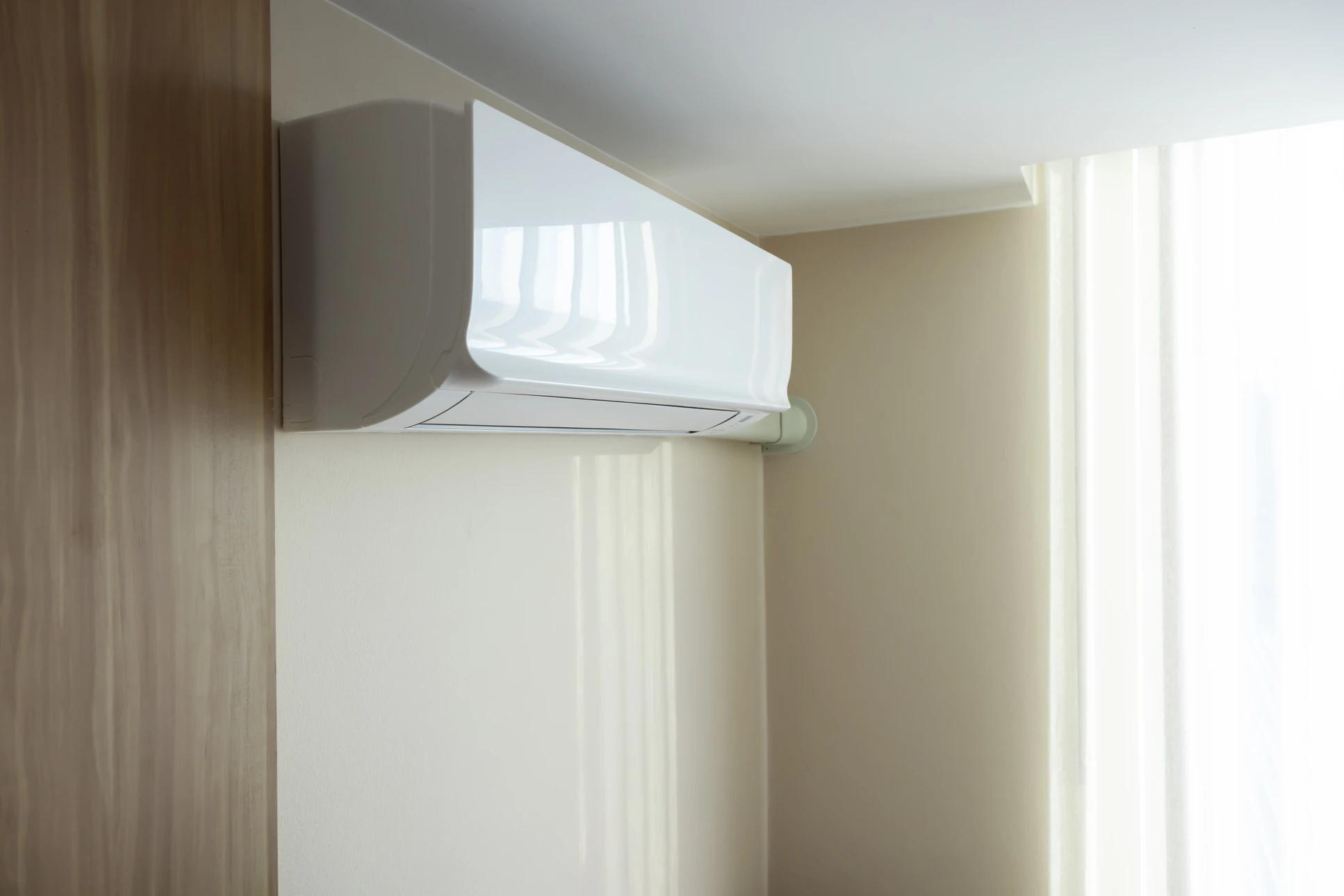 Façade extérieure en bois naturel d'une habitation avec climatiseur split monté sur support métallique